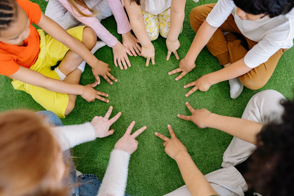 Enfants faisant classe dans l'herbe